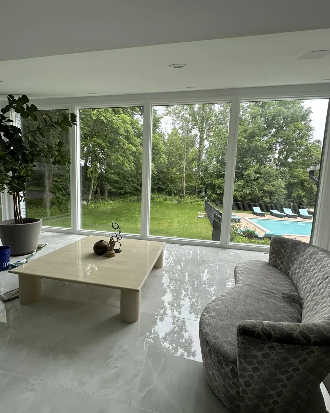 Living room with Kepler window film on floor-to-ceiling windows overlooking a pool